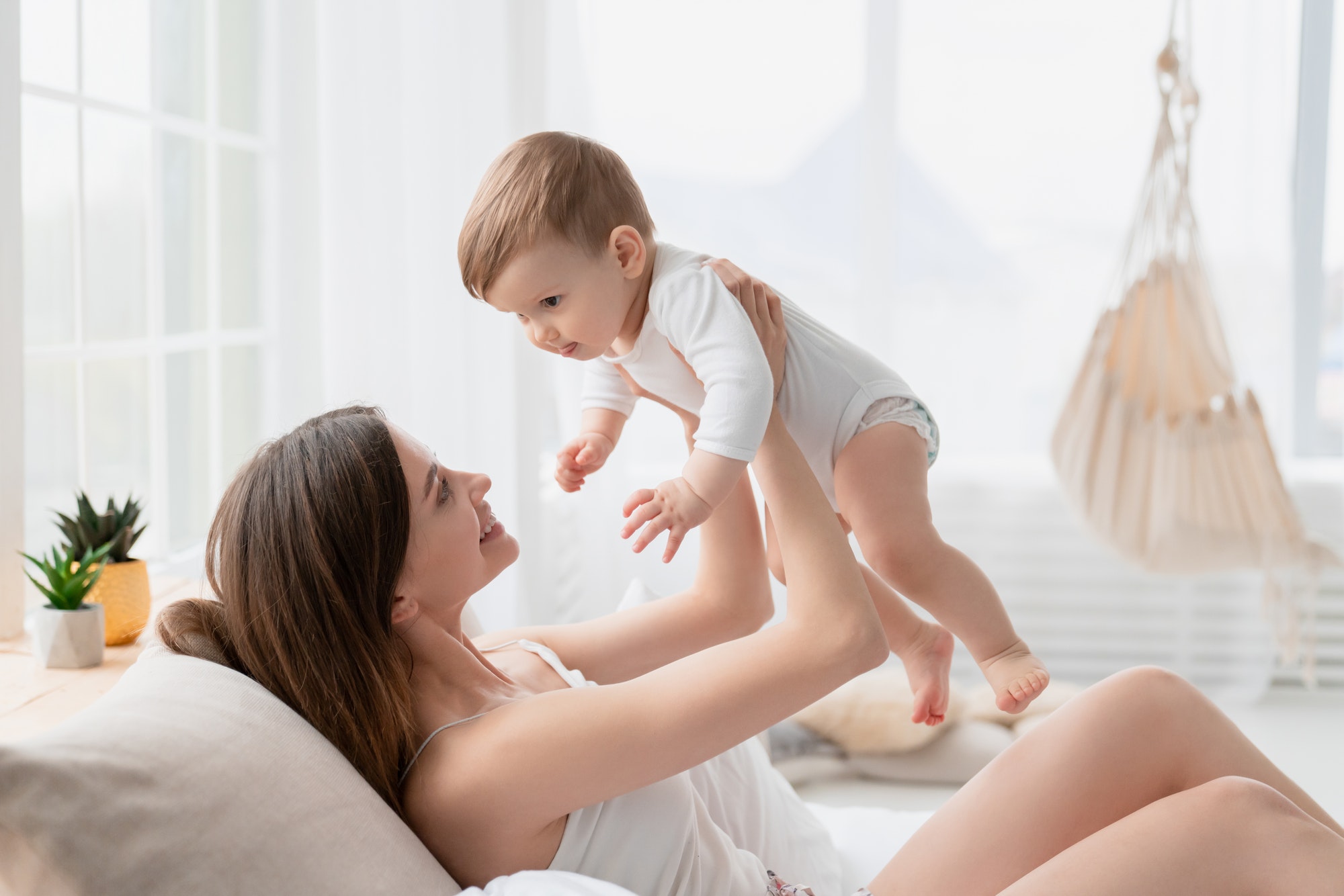 young-caring-mother-playing-taking-care-of-her-newborn-toddler-infant-son-daughter-baby.jpg