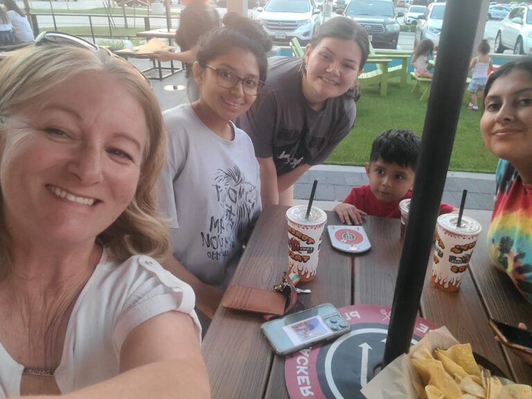 women smiling for a photo while out to eat.